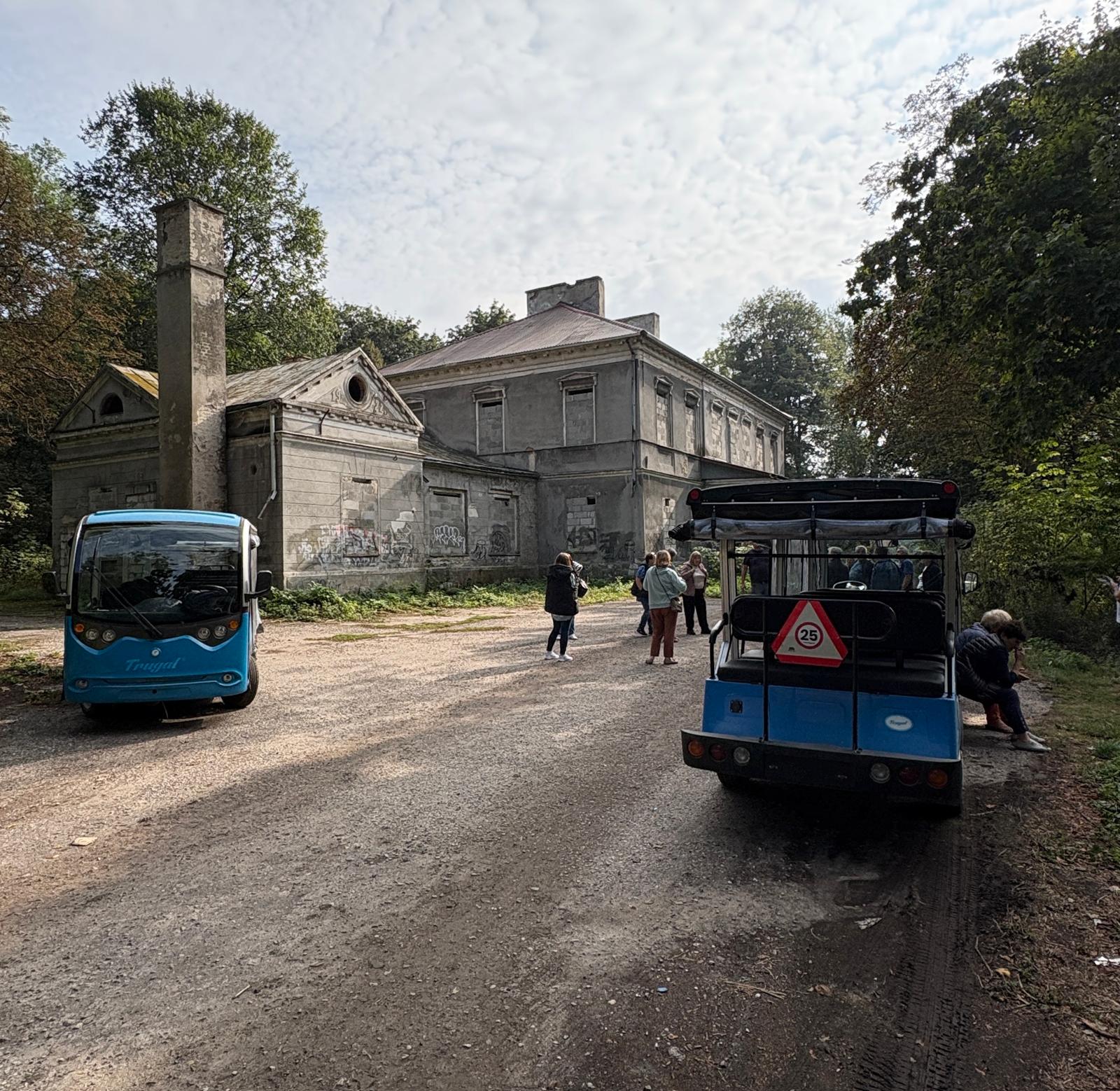 Członkowie Koła Gospodyń Wiejskich przy Niebieskich Ekobusikach na tle pałac w Olesinie
